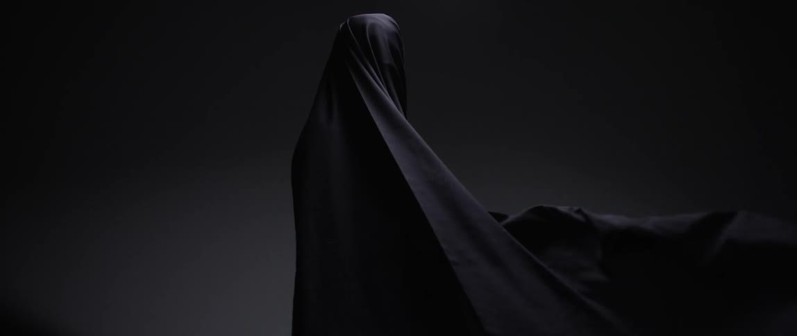Person covered in a large sheet that is blowing in wind