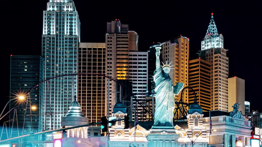 Vehicles pass by a hotel and casino complex in las vegas during the night