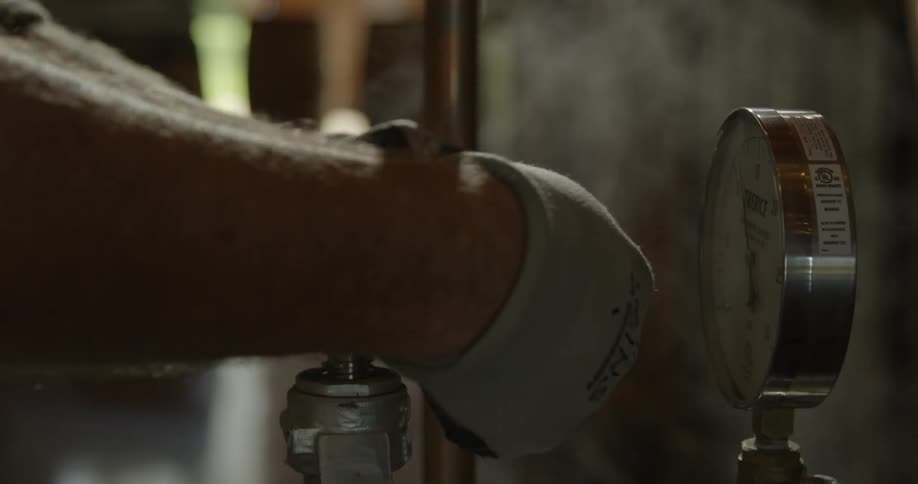 A person turns the valve of a machine