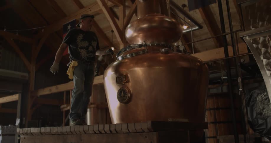 Man opens small door of a large brass kettle