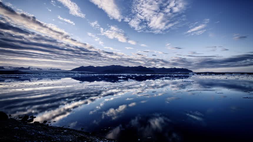 Cloud banks move over icy waters at dawn or dusk