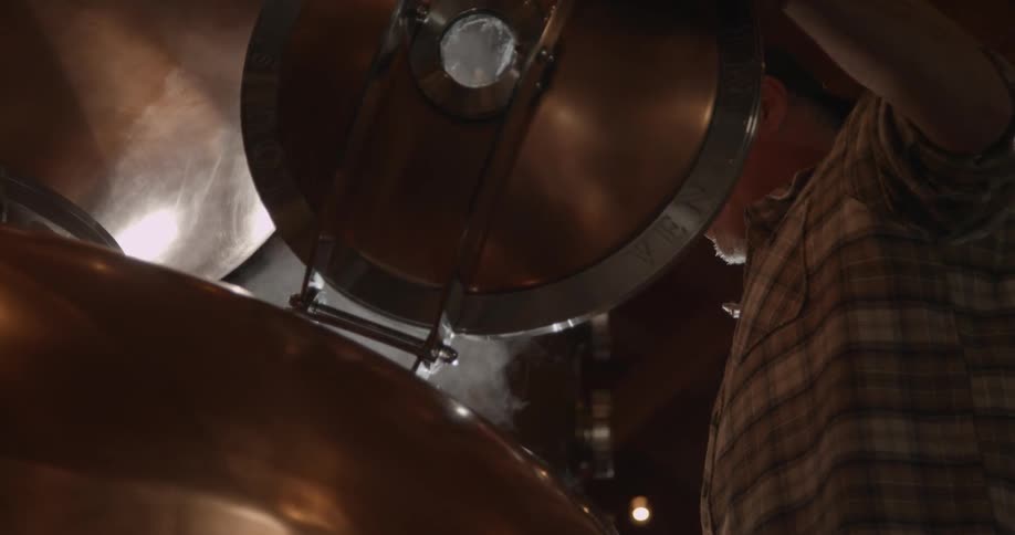 A man opens up a vat and steam rises