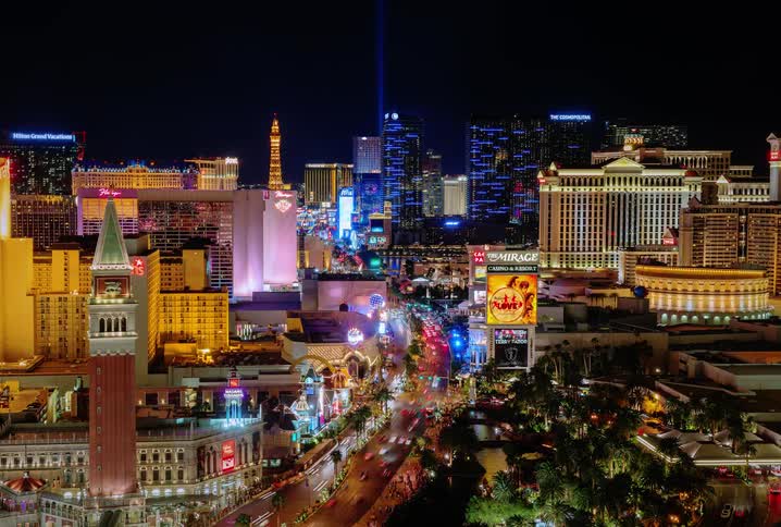 People are traveling through a brightly lit city at night