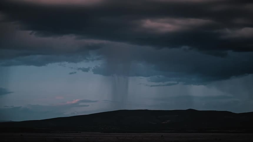 Rain pouring down on a hill as lightning strikes