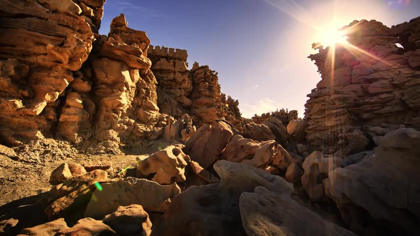 Sunlight shines down on rock formations in the desert