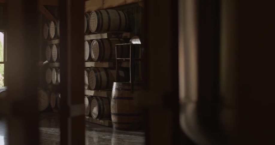 Man writes on clipboard looking at a wall of barrels