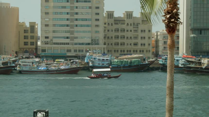 A small, covered boat travelling through a marina