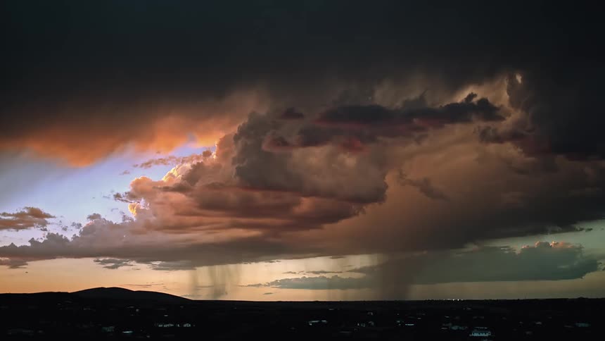 The large clouds ahead shoot lightning and pour rain over the town
