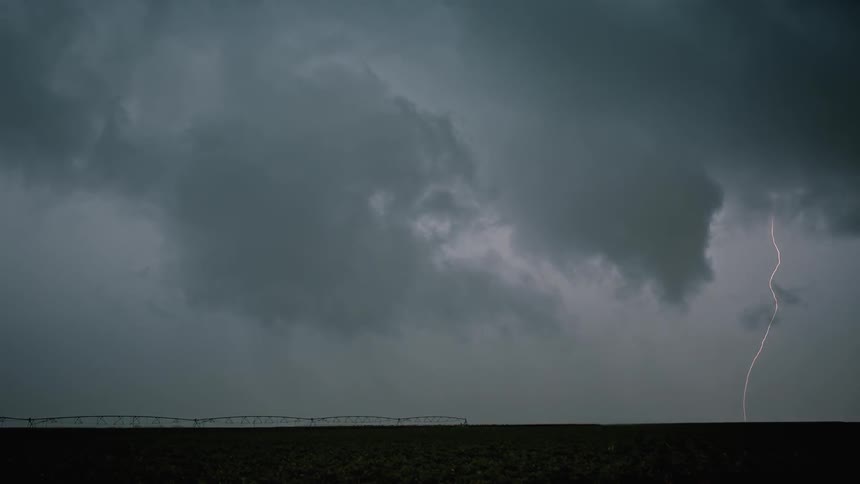 Lightning flashes in the sky over a rural field