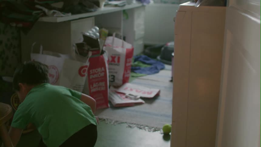 Boys carry wrapped presents out of a room