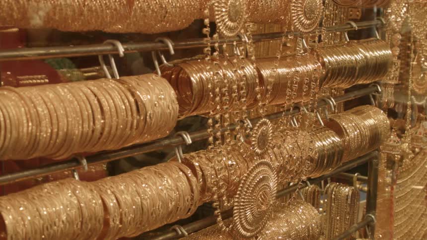Rack of shiny gold bracelets and necklaces