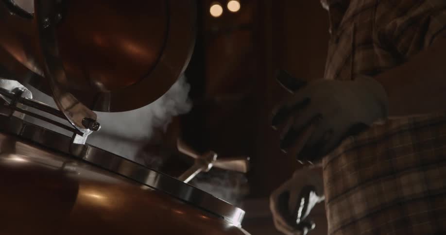 Steam escapes from an open hatch in a distillery