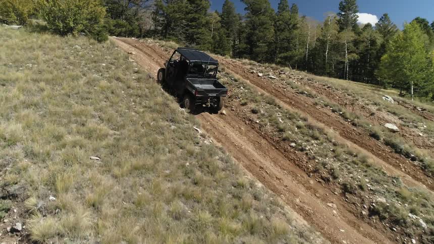 People ride in off road vehicles in the mountains
