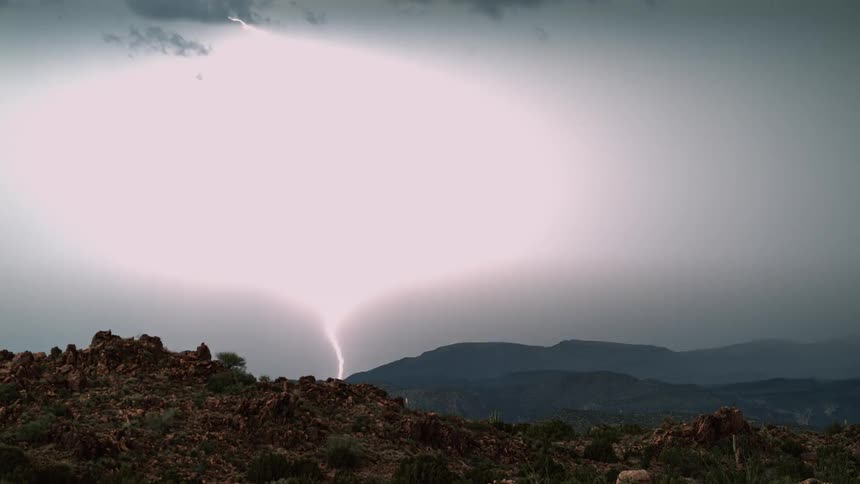 Lighting strikes the ground of the hills ahead