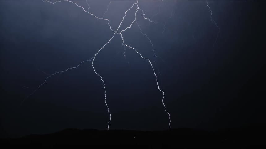 The night sky fills with many bolts of lightning branching out