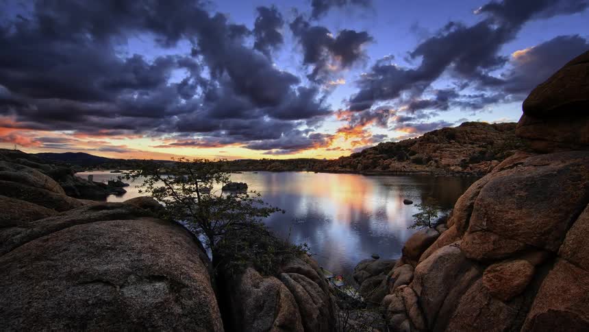 Clouds pass over a lake in the wilderness at sunset