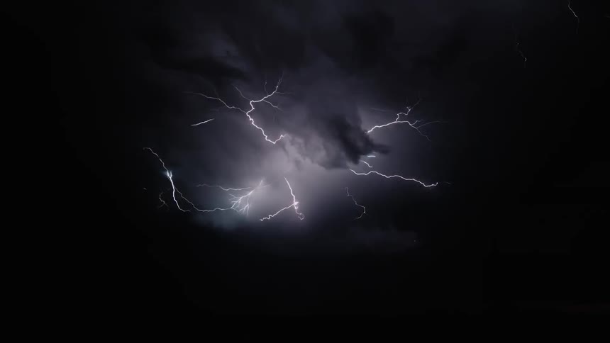 The dark clouds spark lightning to fill the sky with light