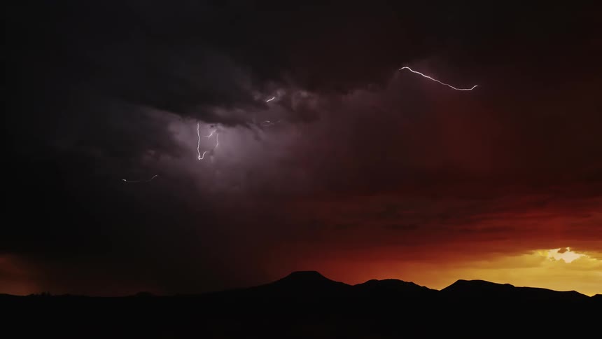Lightning flashes and moves within the body of a storm at dawn