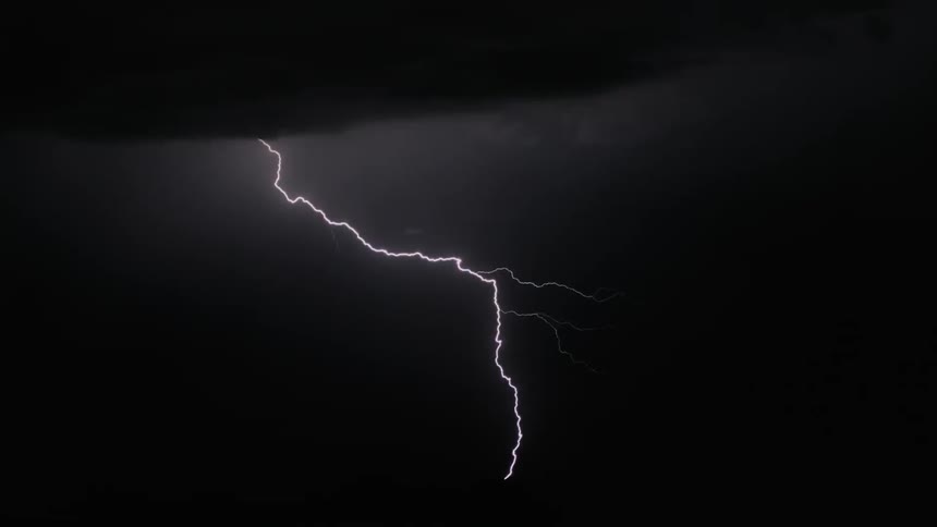 Lightning flashes across a night sky