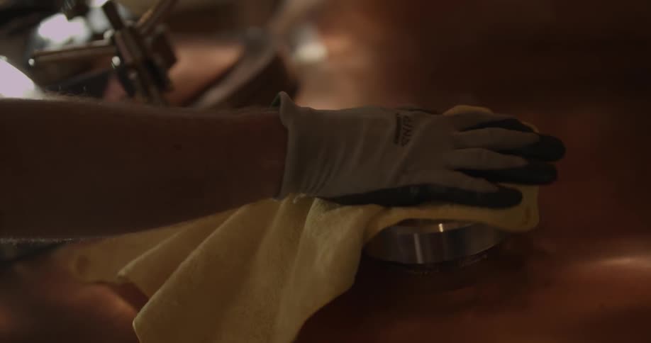 A person polishes machinery