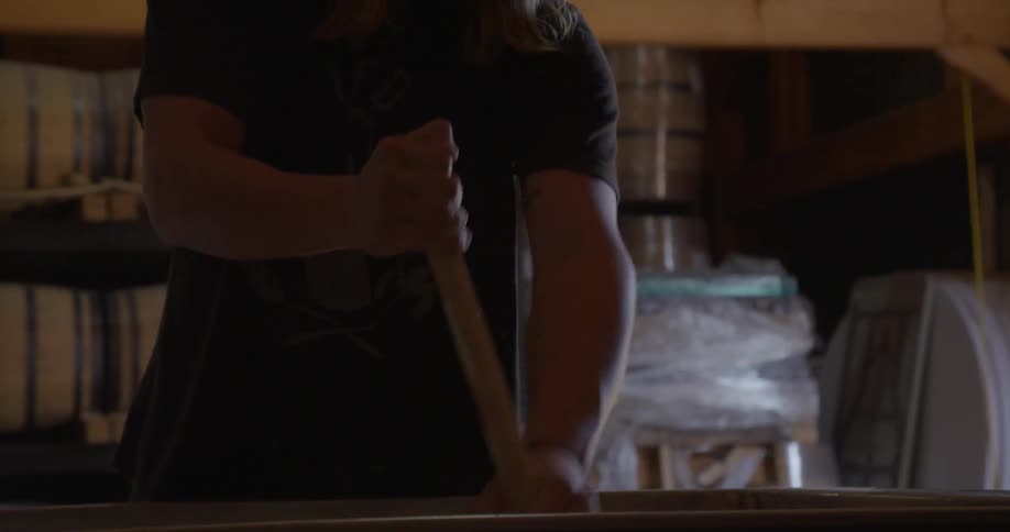 Person stirs in a large tub with a stick