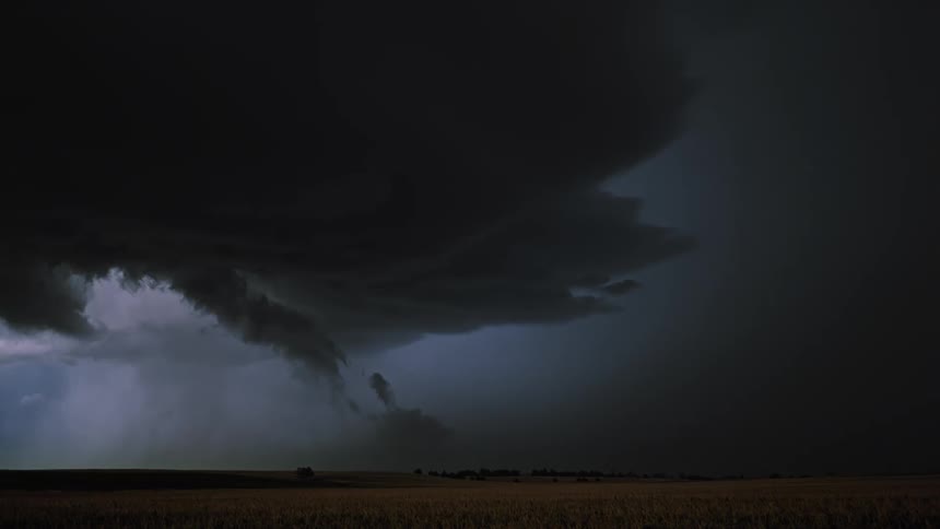 A large black cloud pours rain and sparks lightning