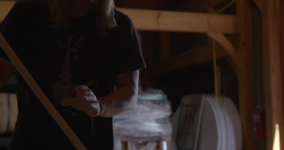 A man is mixing a vat in a distillery