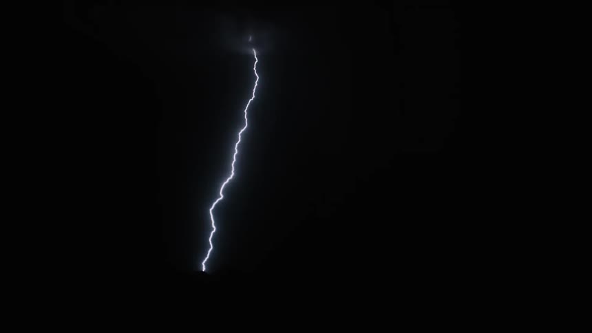 Lightning bolts flash in a black night sky