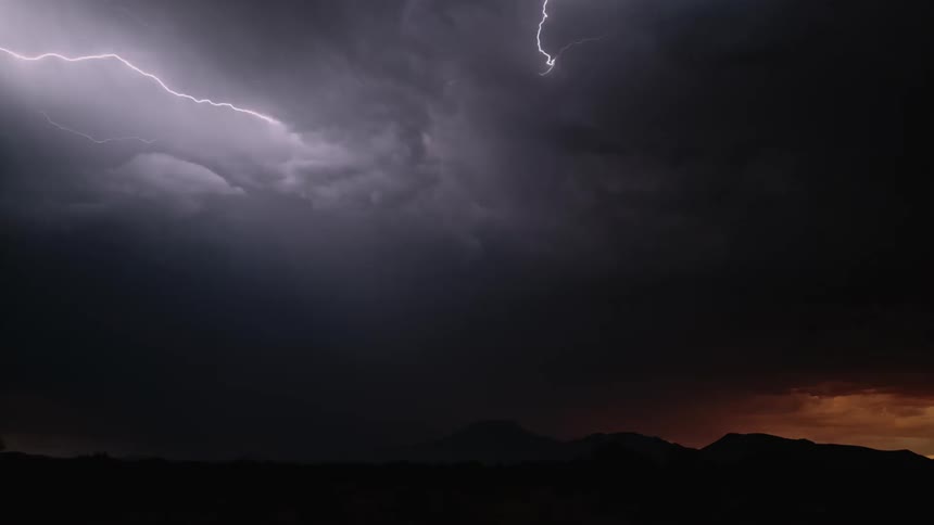 Lightning bolts flash in a night sky