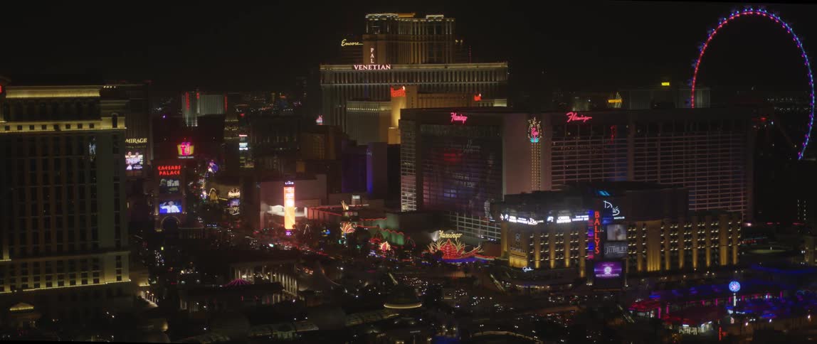 View of a brightly lit city with many people walking in the streets below