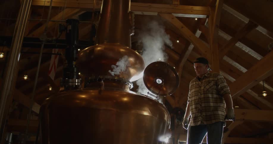 Man looks into a large steaming kettle