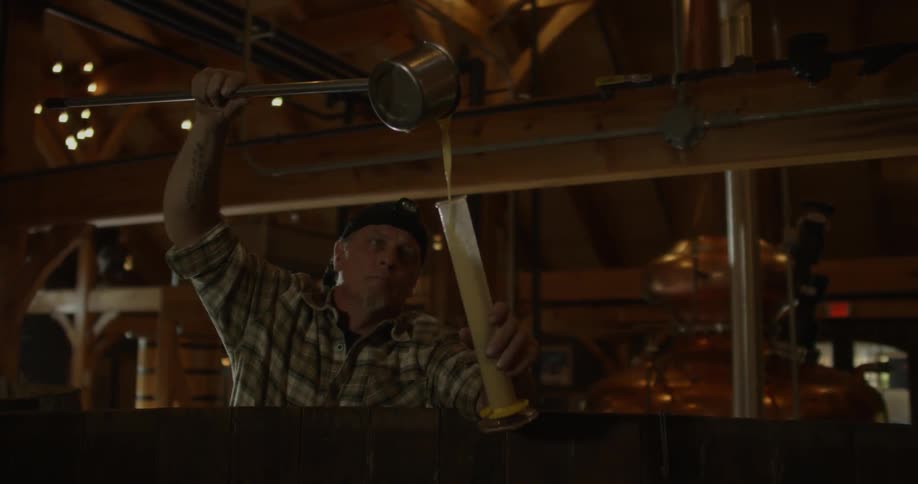 A man pours liquid into a large vial