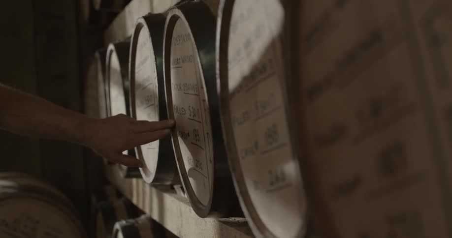 A man checks the barrels in a distillery