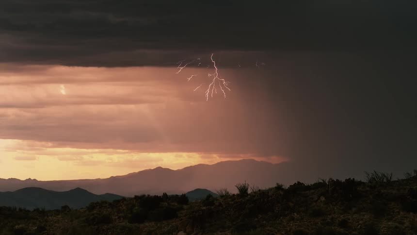 Lightning flashes during a storm in the wilderness at sunset