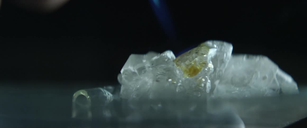 Brown liquid dripping onto a crystal object