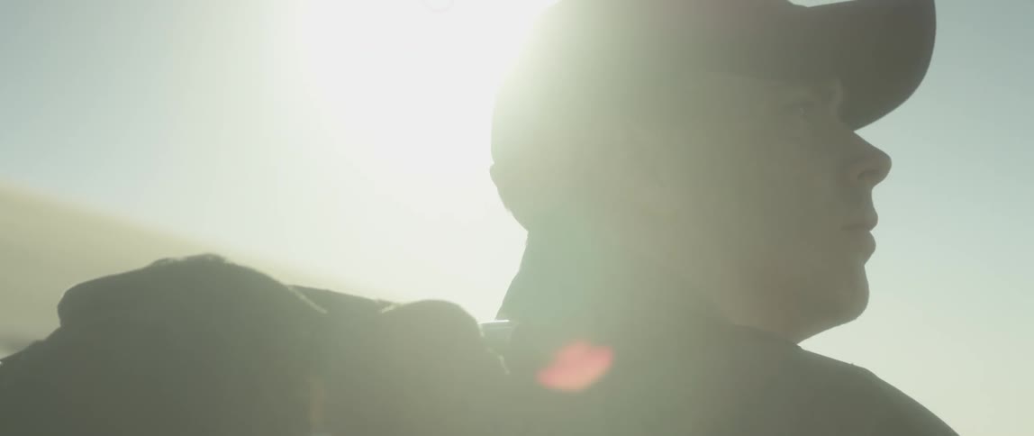 Man sitting under a bright sun