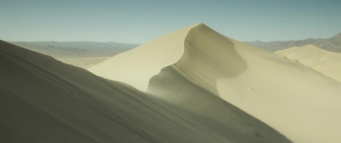 Sand billowing off of a sand dune