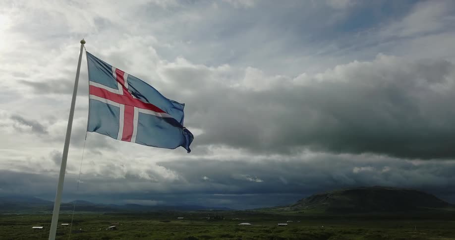 The flag of iceland waves in the wind on a cloudy day