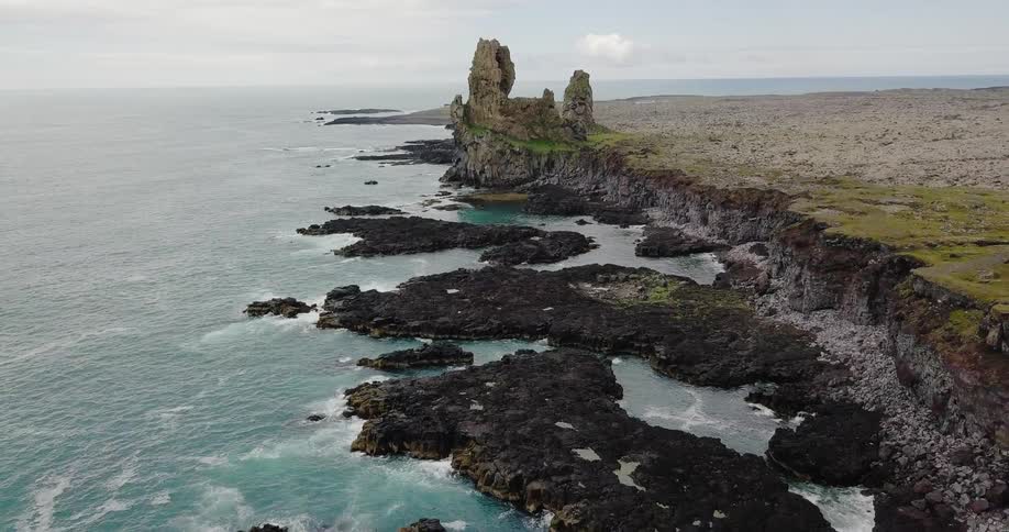 The ruined remains of an ancient building stand on a cliff overlooking the ocean