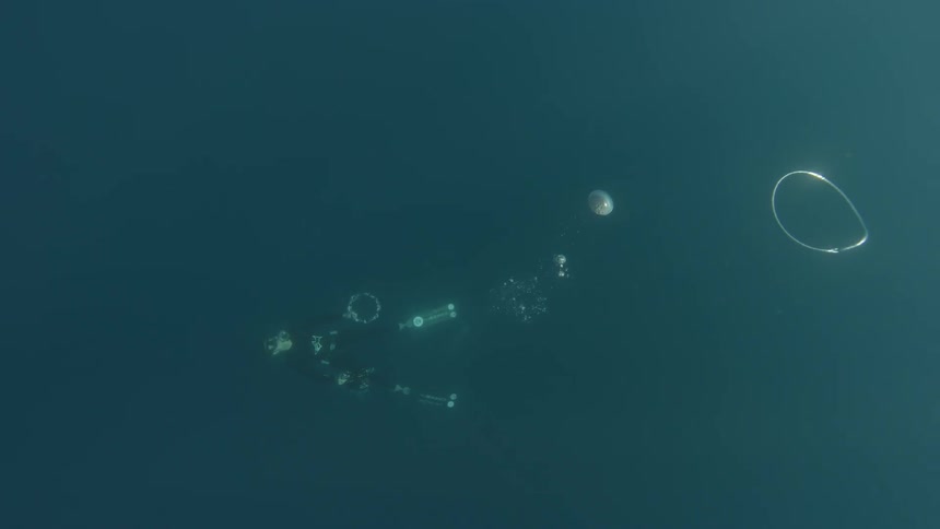 A diver is swimming underwater and trailing large bubbles