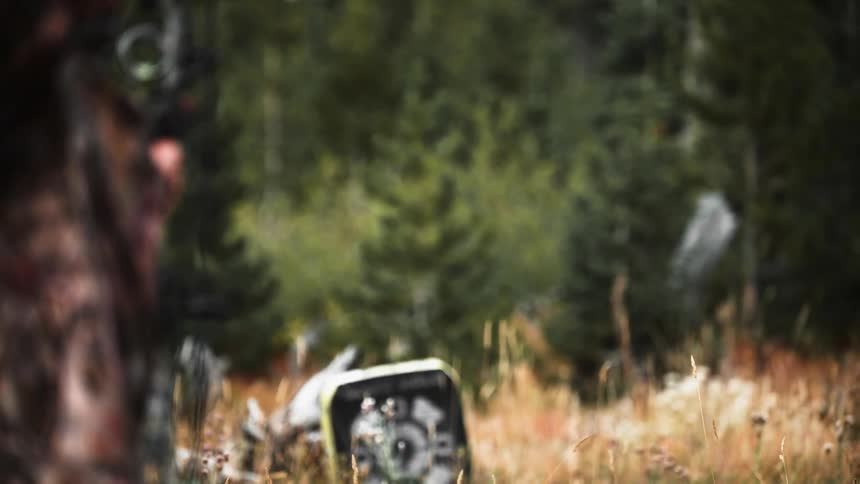 Man wearing camouflage shoots an arrow
