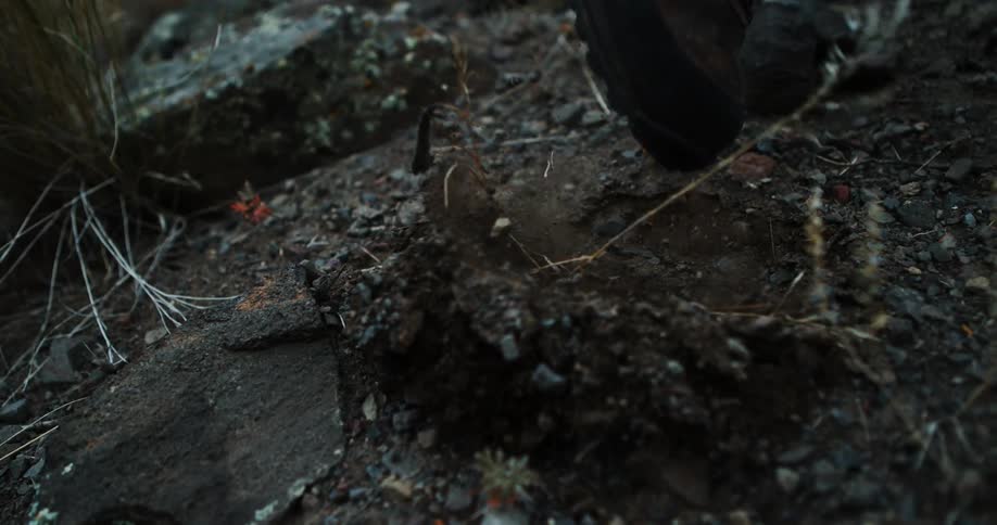 Boot steps on muddy terrain and lifts up