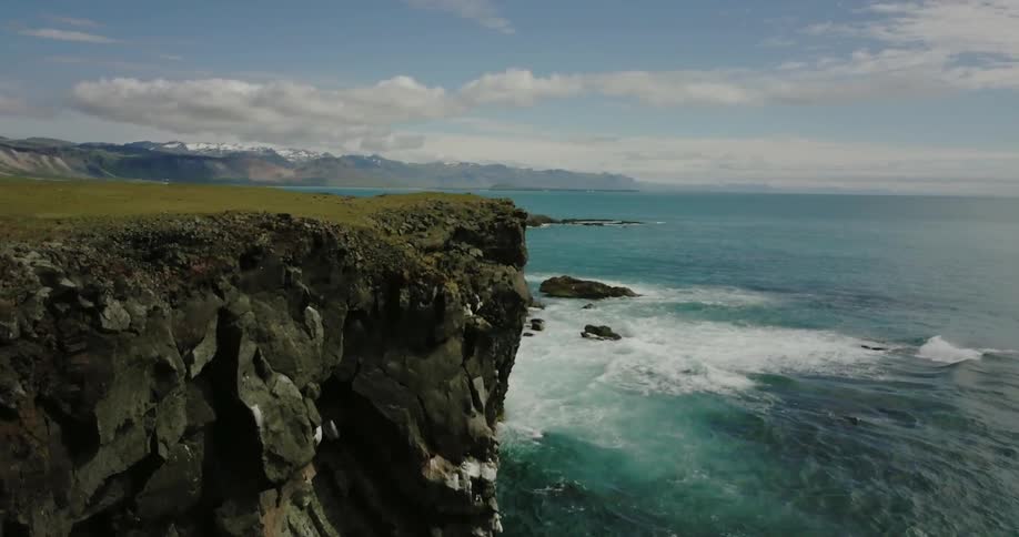 Ocean waves crash into a rocky cliffside