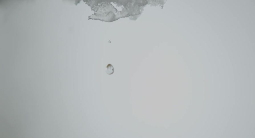 A drop of water drips off some ice