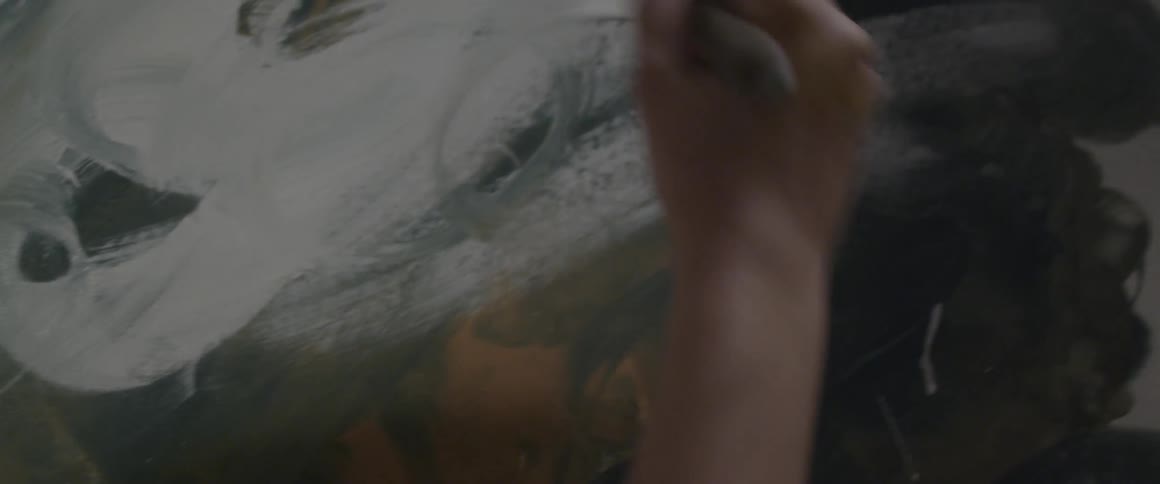 Person painting white on a board