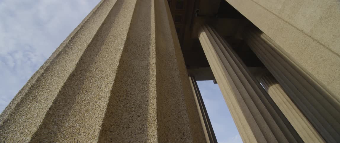 View of some very tall stone pillars on a cloudy day