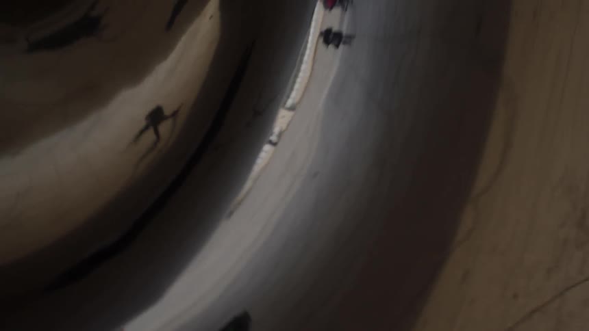 People are reflected on a metallic surface