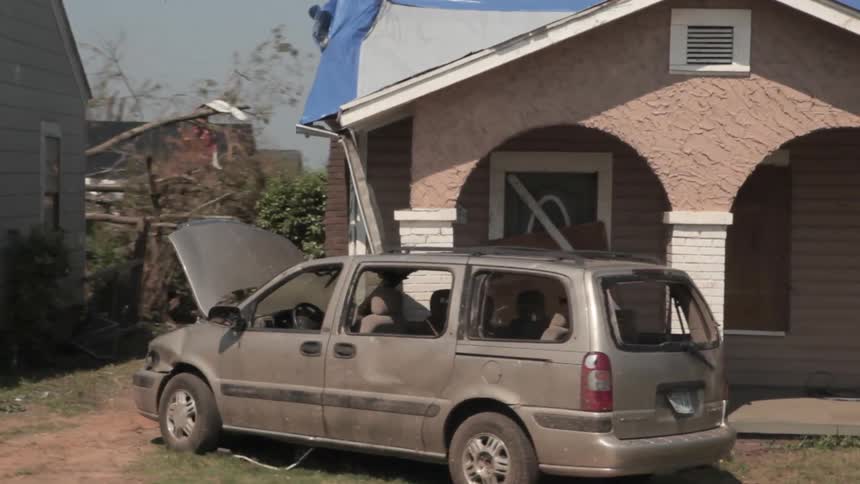 View of some wrecked homes with a van next to it
