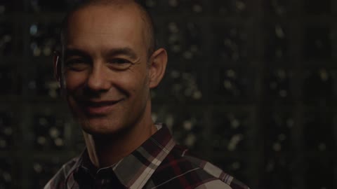 Man stares up and gives a bright smile