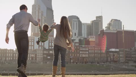 A couple swing their child